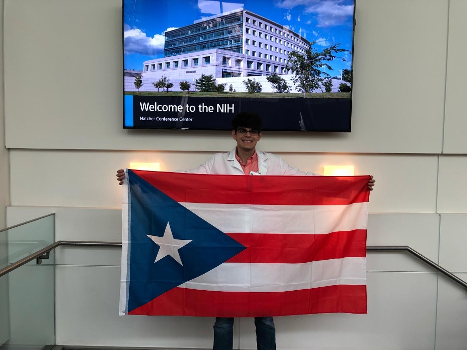 Joseph holding the Puerto Rican flag at the NIH.